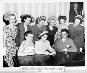 Legion of Young Polish Women President Henryka Grajewska signs a $2,000 check for the Polish American Congress for the Committee for Resettlement of Polish Displaced Persons.