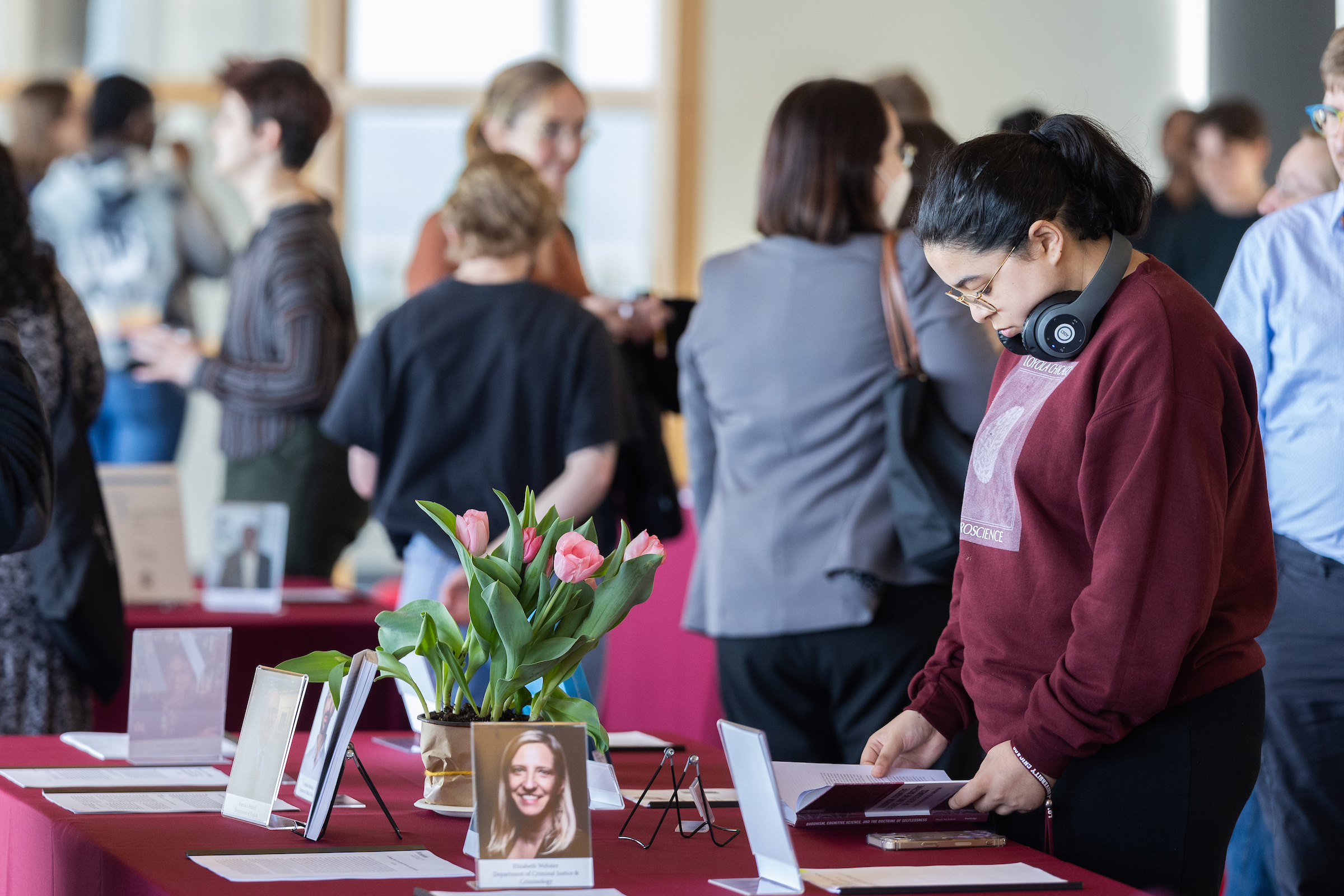 person looking down and reading material that is on top of a table; display of articles and photos