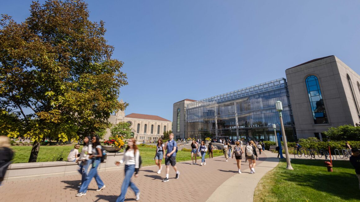 group of people walking in front of Loyola Information Commons