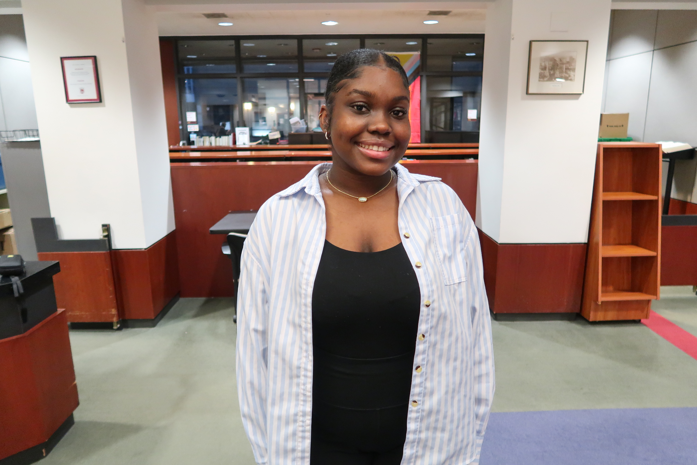Loyola student, Candace Mack, poses in front of the Lewis Library Circulation Desk