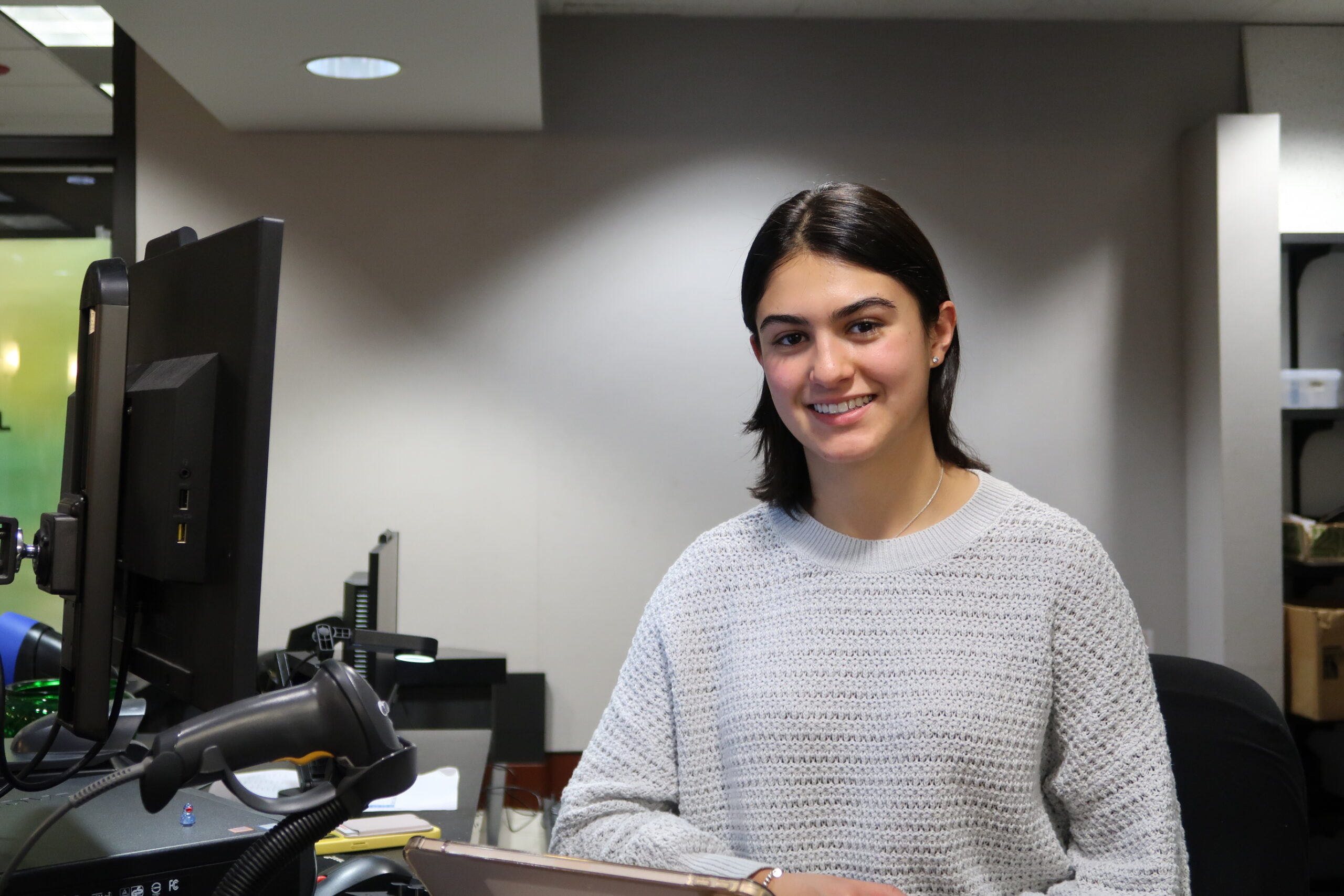 Student worker, Manuela, sits at the Lewis Library Circulation Desk