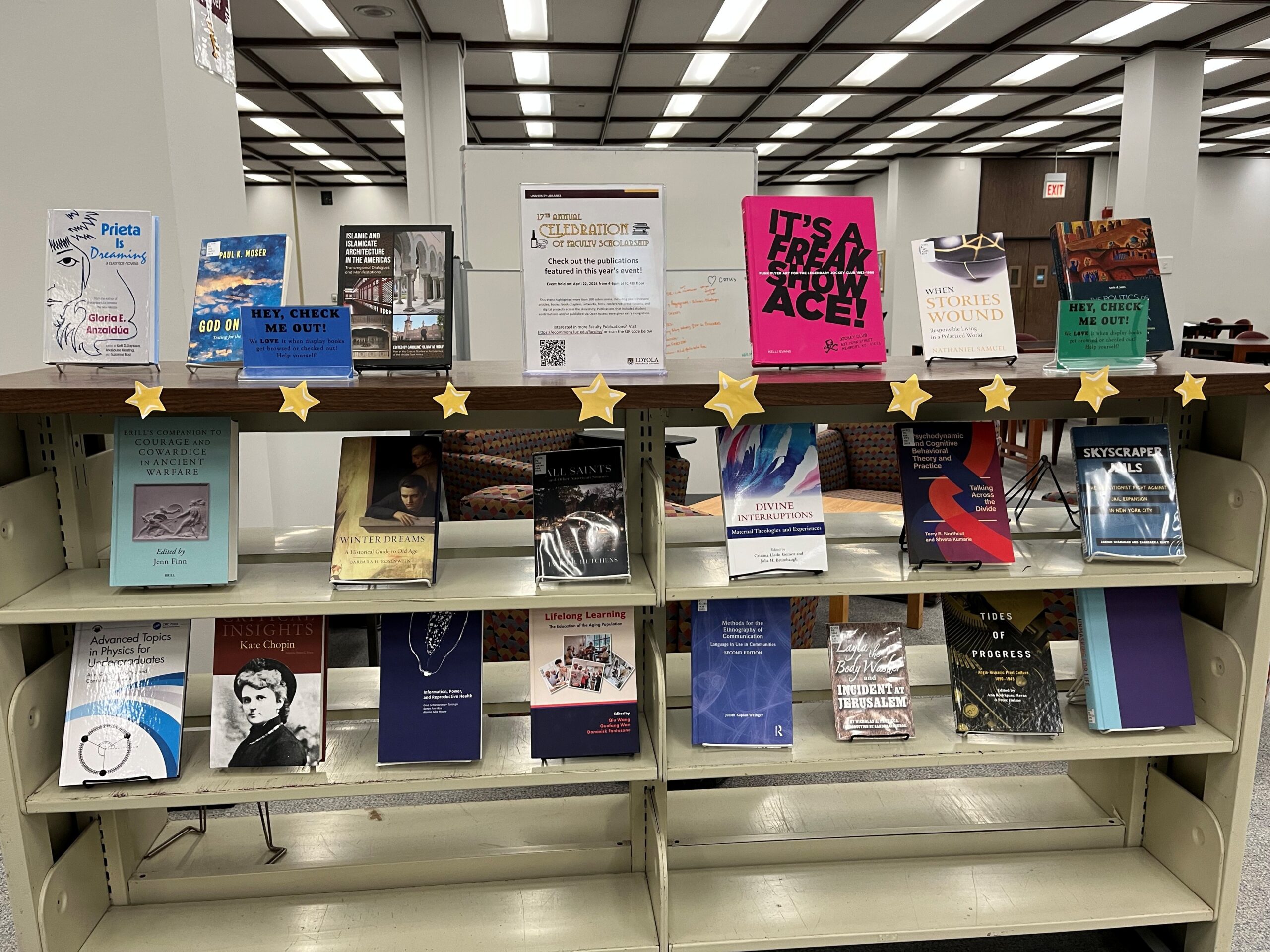 A bookshelf displaying three rows of books from the Celebration of Faculty Scholarship