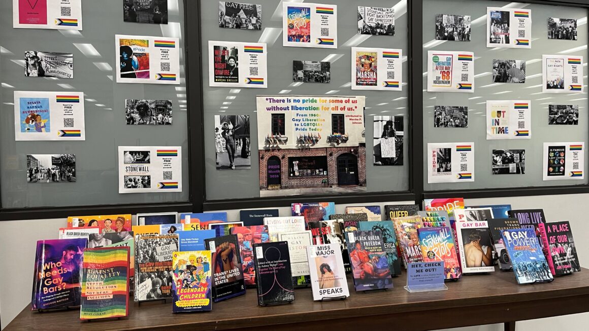 an array of books on a table and photos on a wall are displayed