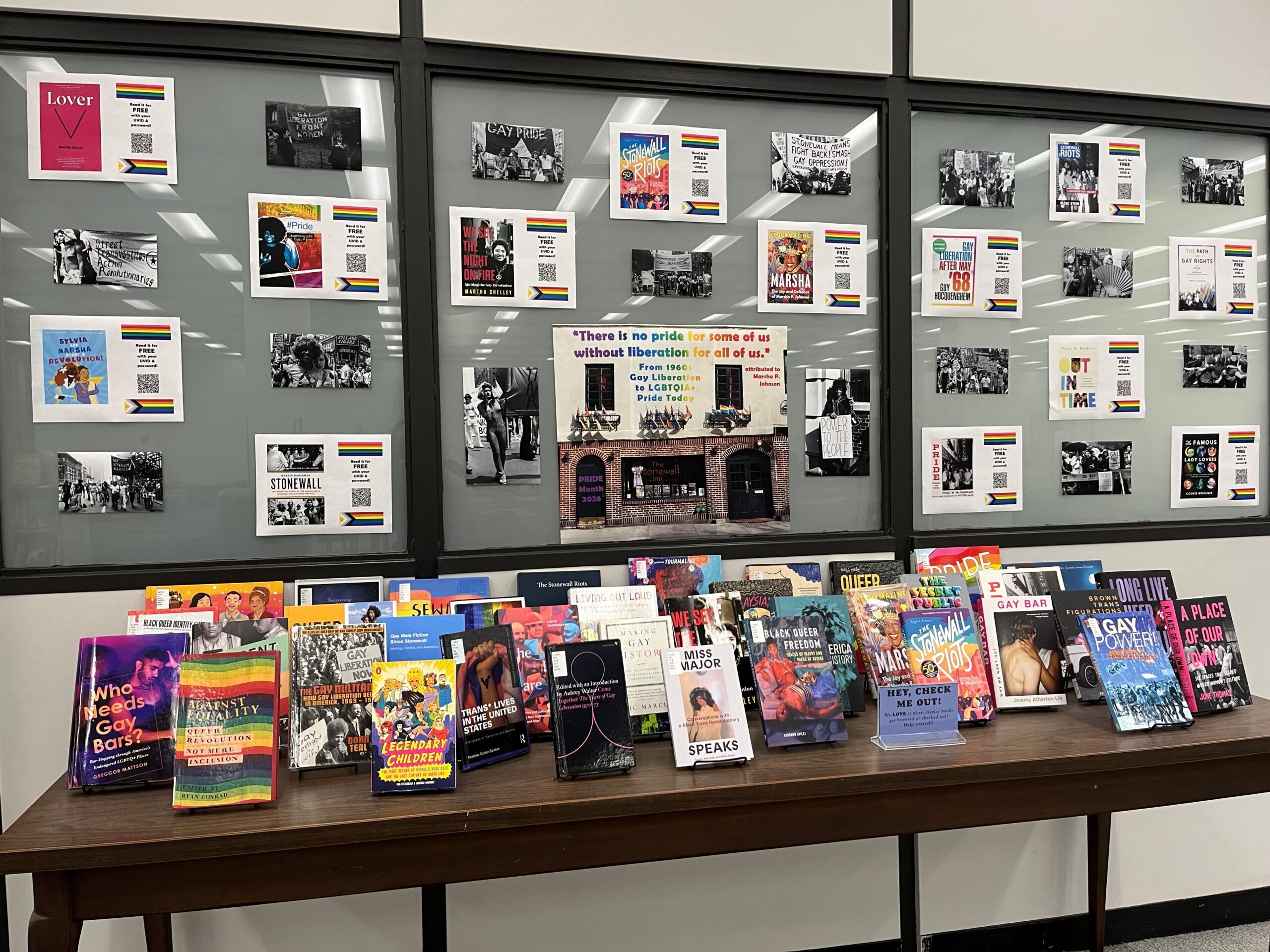 an array of books on a table and photos on a wall are displayed